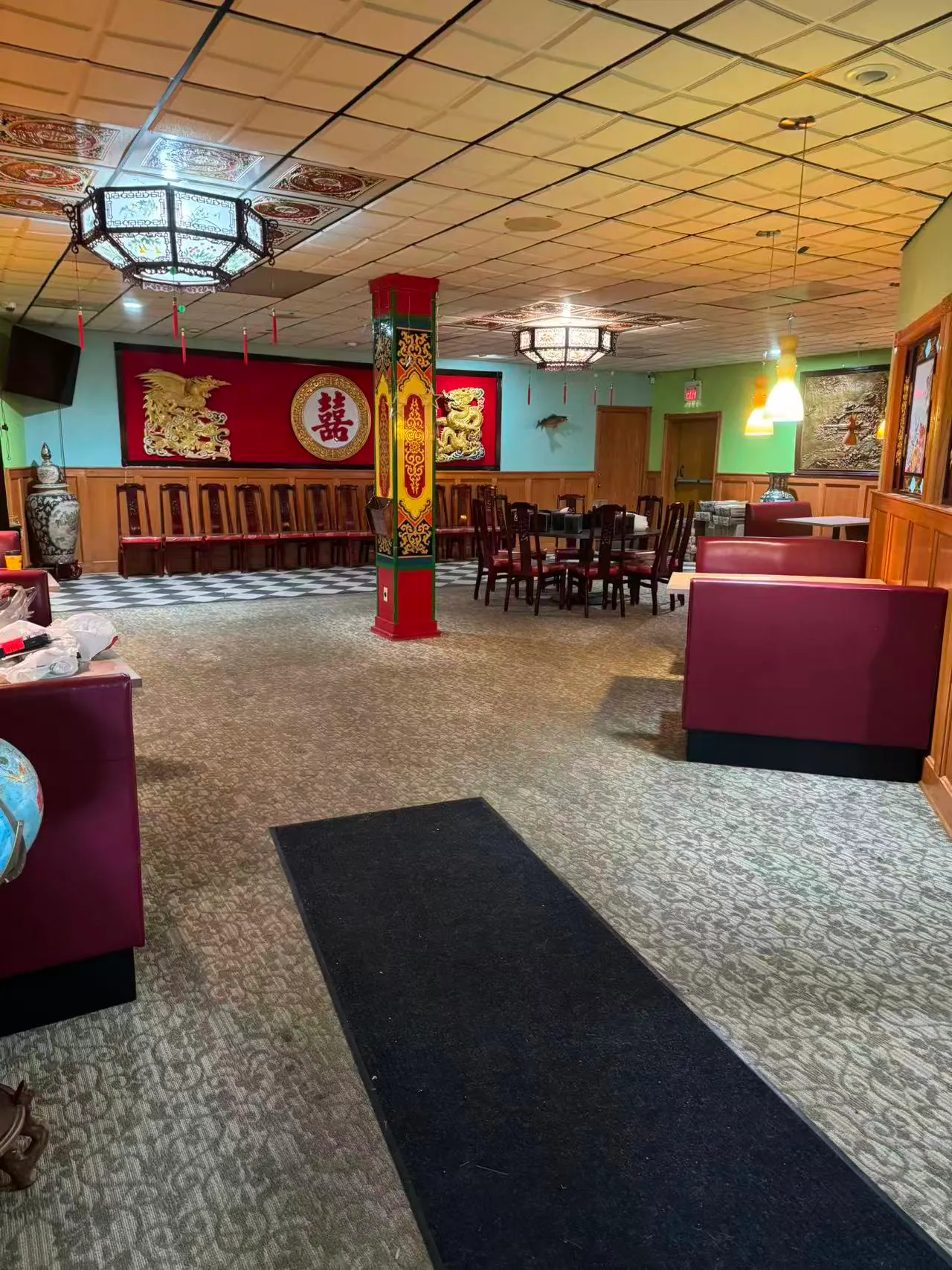 China-King-Chinese-Restaurant-Restaurant-Display-South-Beloit The interior of a Chinese restaurant featuring a decorative red pillar with golden dragons, a “囍” (double happiness) emblem, booth seating, and patterned carpeting.